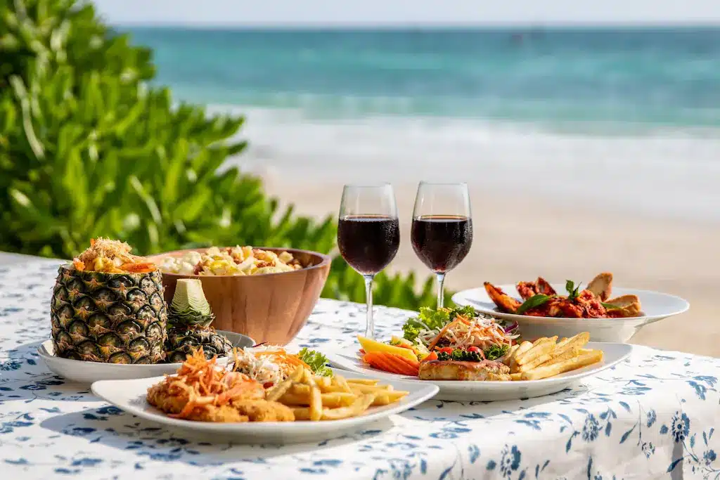 โต๊ะริมชายหาดอันหรูหราพร้อมจานอาหารและไวน์ ที่พักเกาะล้านติดทะเล
