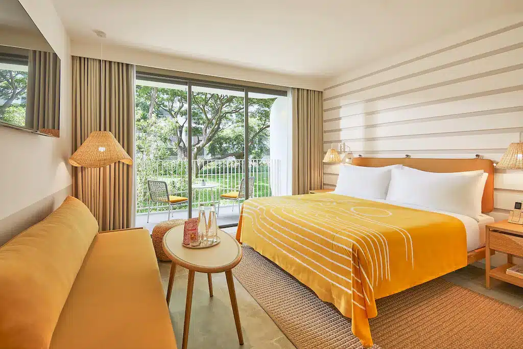 ห้องพักในโรงแรมที่มีเตียงสีเหลืองและระเบียง ที่พักเขาตะเกียบ
