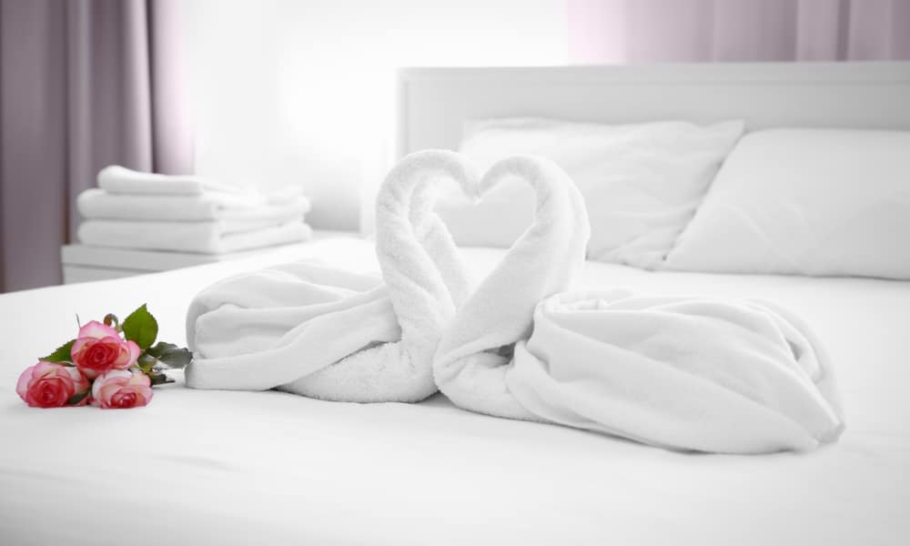 เตียงนอนสีขาวมีดอกกุหลาบชมพู่บรรยากาศโรแมนติก ที่พักพิษณุโลก