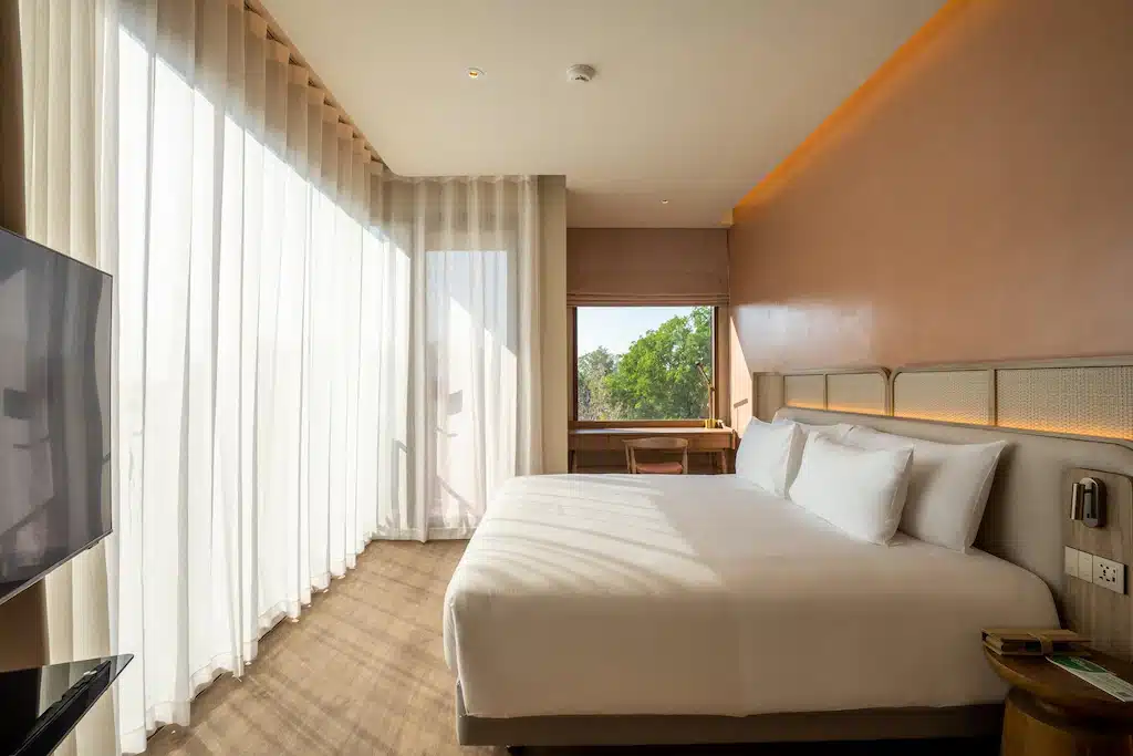 ห้องพักในโรงแรมที่มีเตียงขนาดใหญ่และทีวีจอแบน อุบลราชธานีที่เที่ยว