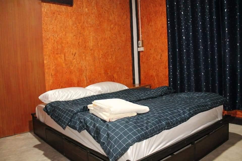 เตียงหรือเตียงในห้องที่มีผนังสีส้ม รีสอร์ทอ่างทอง