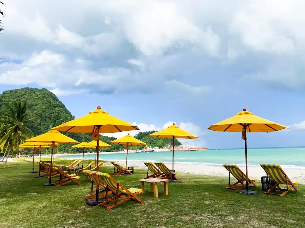 ชายหาดที่มีร่มและเก้าอี้สีเหลือง ที่พักขนอมติดทะเล