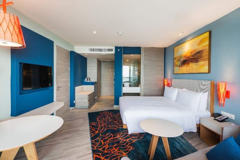 ห้องพักในโรงแรมที่มีผนังสีฟ้าและเตียง ที่พักเขาตะเกียบ