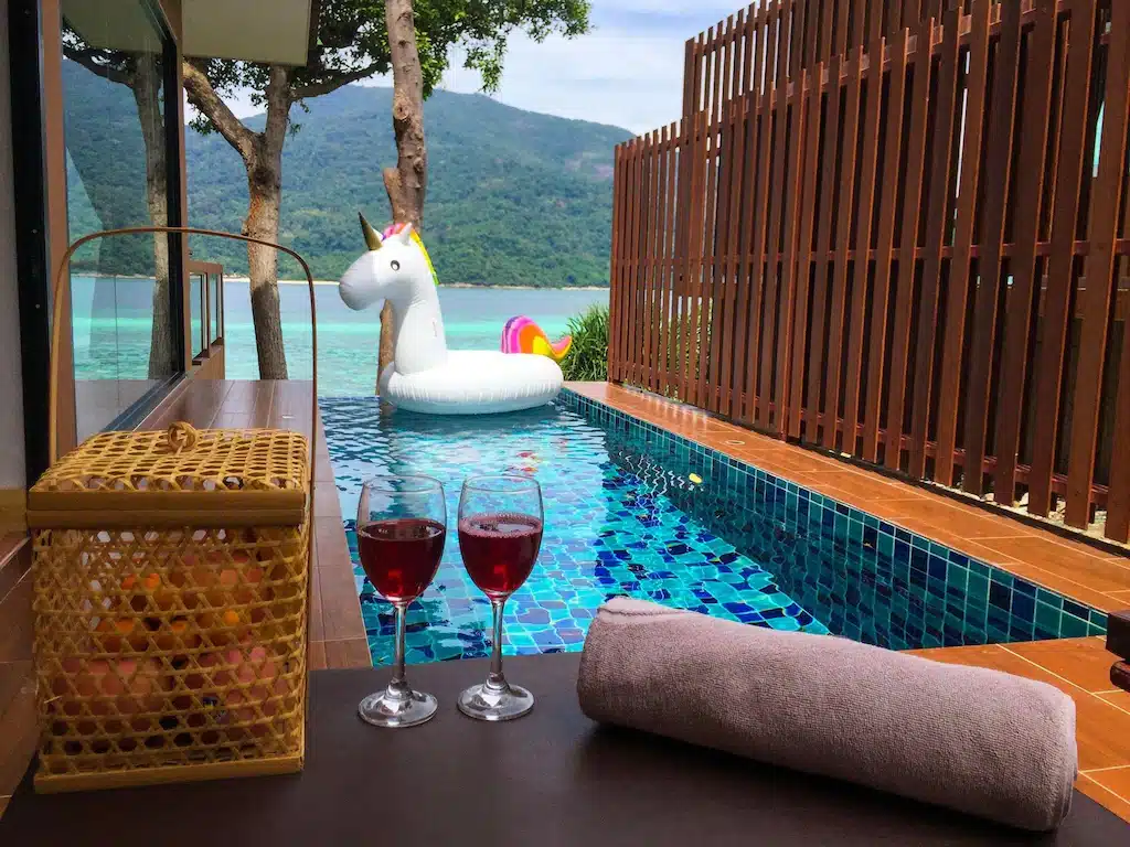 ไวน์สองแก้วบน ที่พักหลีเป๊ะ โต๊ะข้างสระน้ำในราชบุรีที่เที่ยว