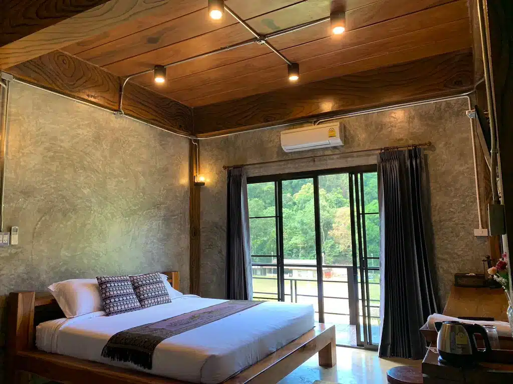 เตียงในห้องที่มีเพดานไม้และพื้นไม้ ตั้งอยู่ใน ที่พักบนดอยเชียงใหม่ ประเทศไทย