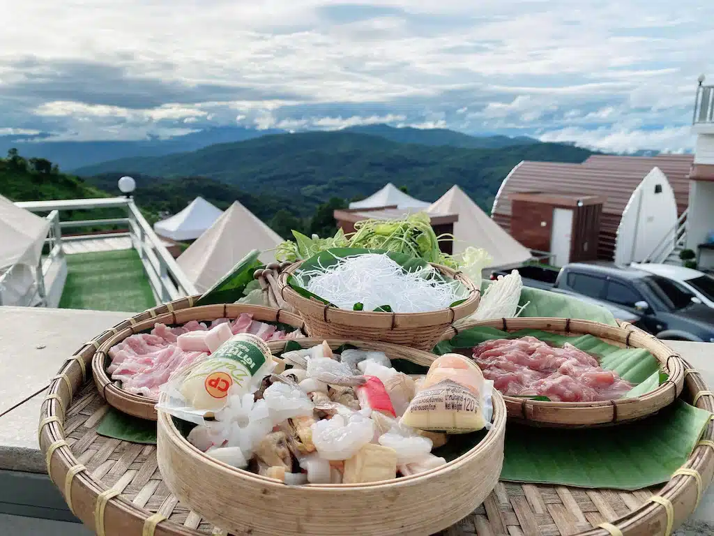 ตะกร้าอาหารบนโต๊ะที่มีภูเขาเป็นฉากหลัง ที่เที่ยวชลบุรี ที่พักบนดอยเชียงใหม่