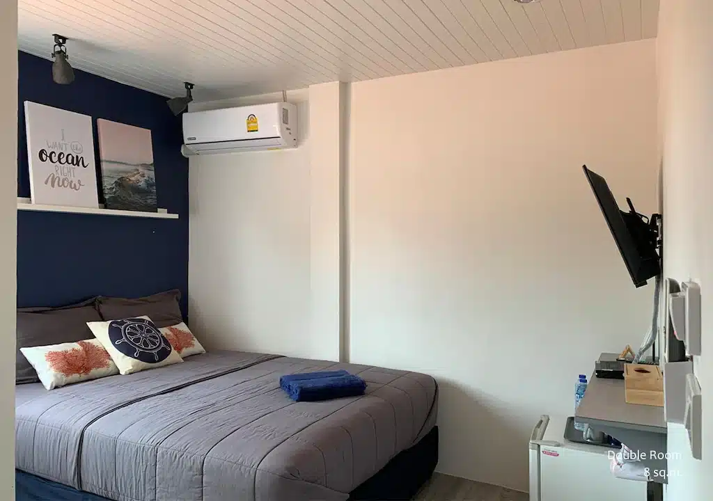 ห้องนอนเล็กๆ ที่มีผนังสีฟ้าและเตียง หาดทรายแก้วรีสอร์ท
