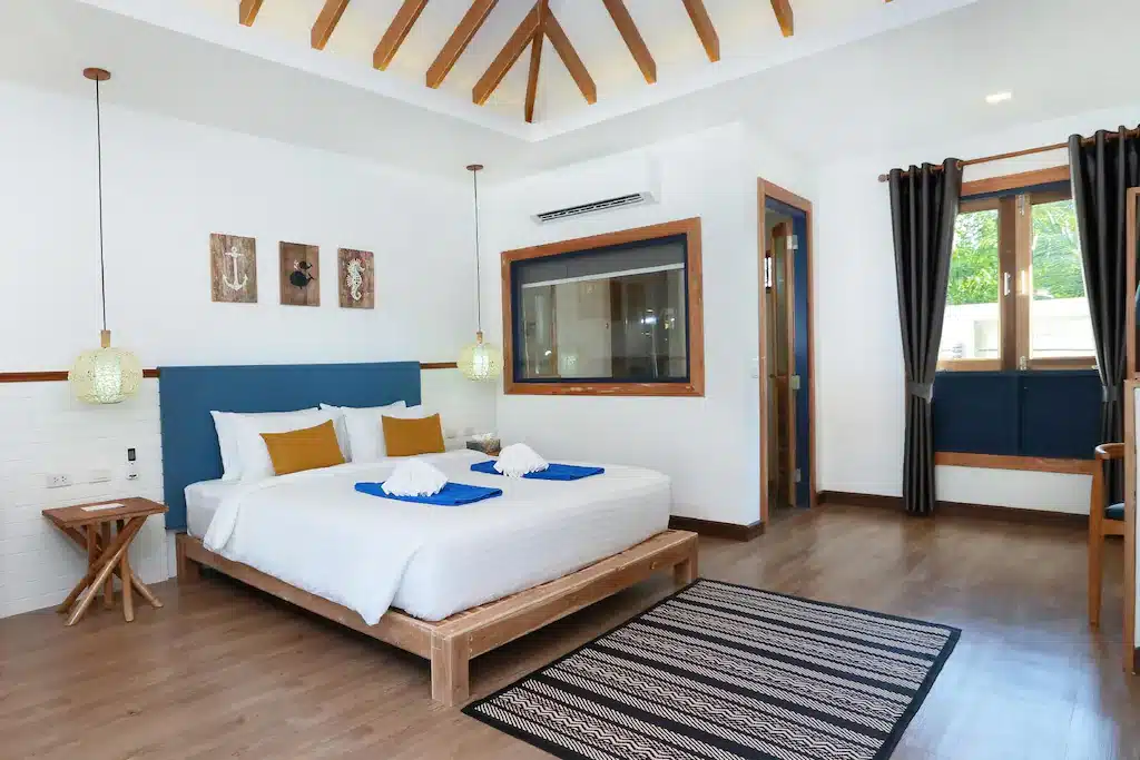 ห้องนอนที่มีเพดานไม้และเตียง ที่พักเกาะลันตา