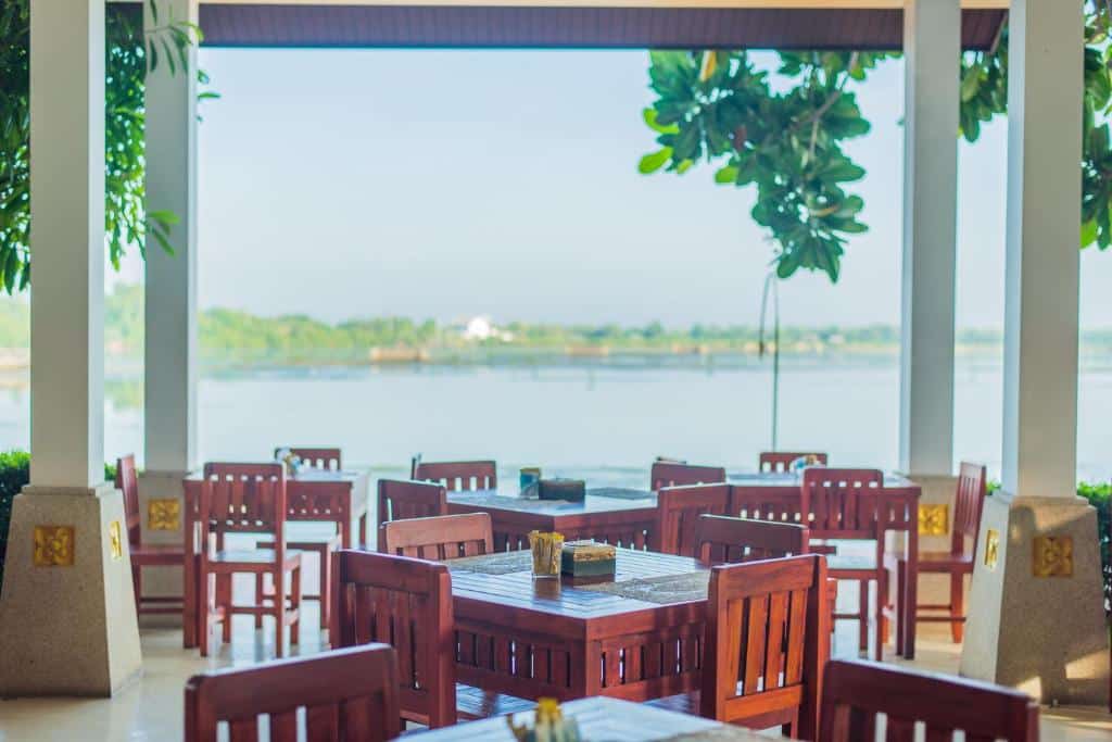 ร้านอาหารพร้อมโต๊ะและเก้าอี้ที่สามารถมองเห็นวิวน้ำได้ในสมุทรสงคราม ที่พักสมุทรสงคราม