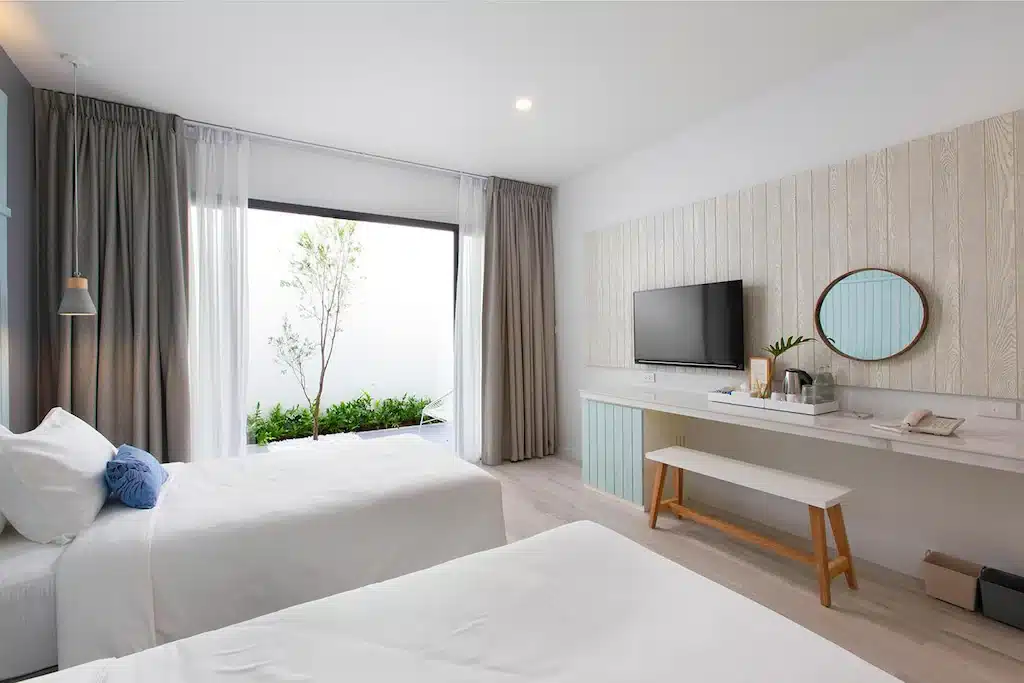 ห้องพักในโรงแรมแบบ 2 เตียง และทีวี ตั้งอยู่ในเมืองระนอง โรงแรมระนอง 