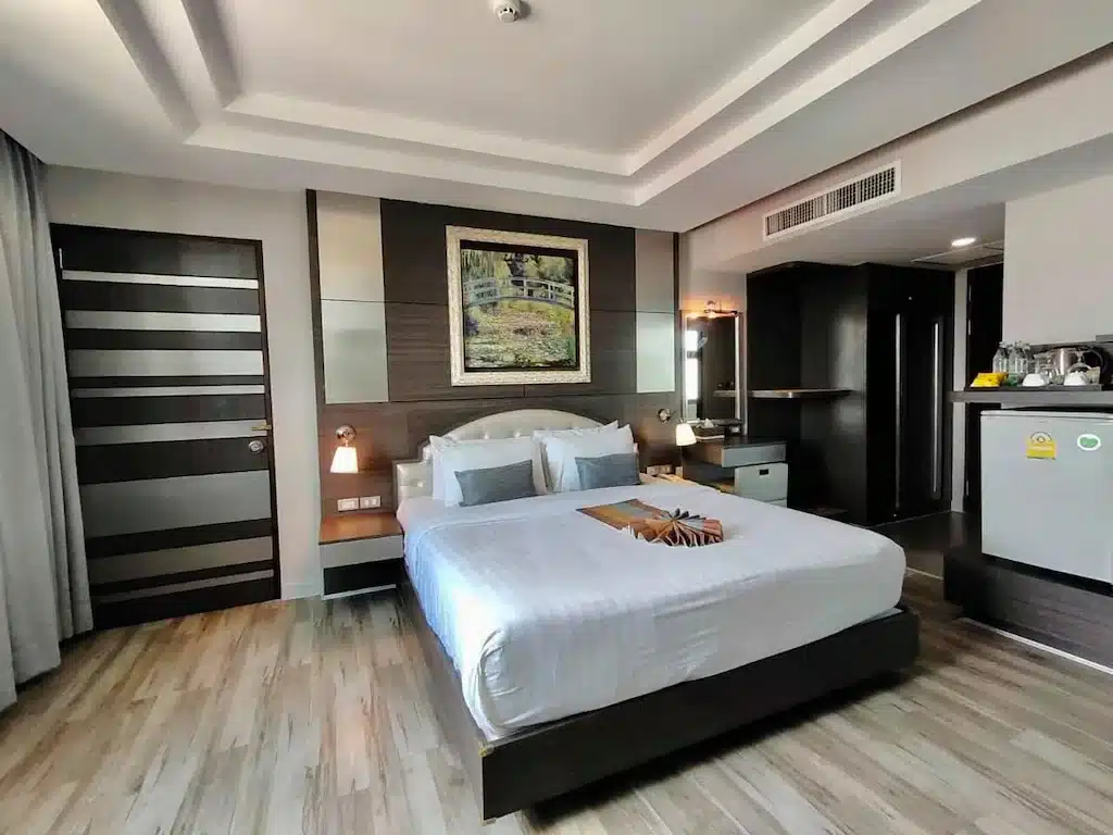 ห้องพักโรงแรมในศรีสะเกษพร้อมเตียงขนาดใหญ่และพื้นไม้ ที่พักศรีสะเกษ