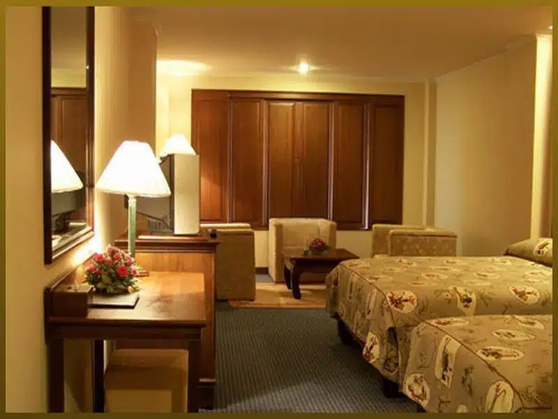 บริการพัทลุงพร้อมเตียง 2 เตียงและโต๊ะในห้องพักในโรงแรม โรงแรมในสุพรรณบุรี