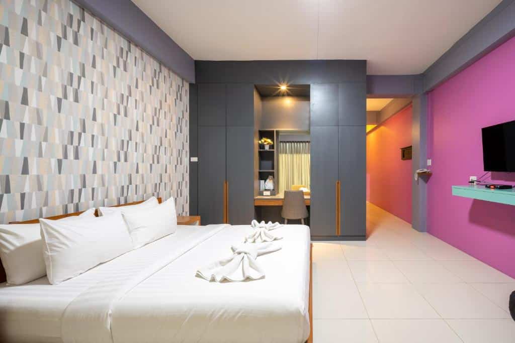 ห้องสีชมพูม่วงพร้อมเตียงและทีวี ตั้งอยู่ในที่พักริมชายหาดในจังหวัดระนอง ที่พักระนองในเมือง