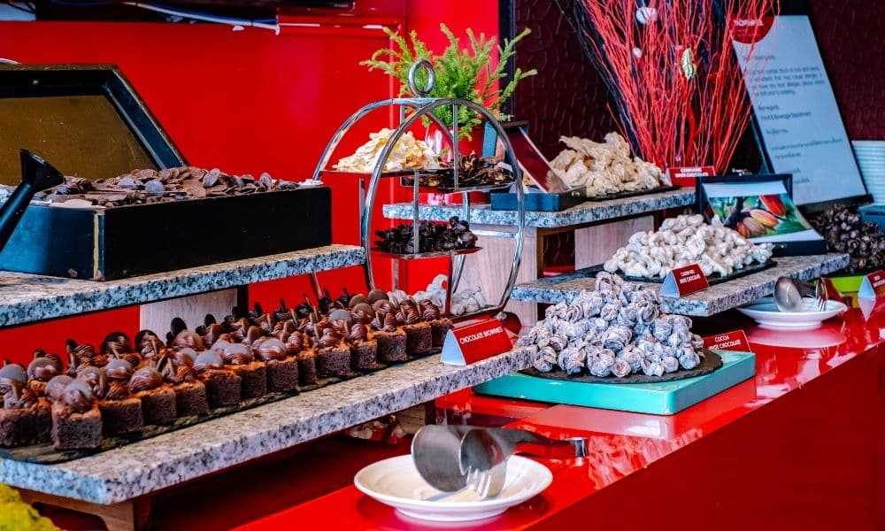 การจัดแสดงช็อคโกแลตและขนมหวานบนโต๊ะสีแดงที่โรงแรมเมอเวนพิค พัทยา โมเวนพิคพัทยา