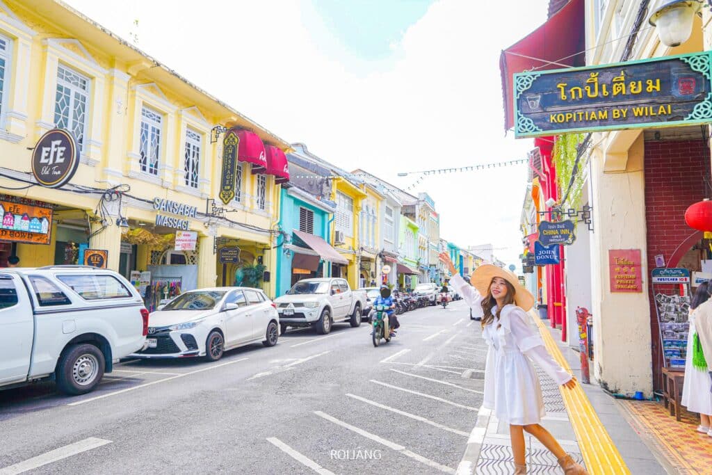 ผู้หญิงในชุดสีขาวเดินไปตามถนนใกล้กับโรงแรมโนโวเทล ภูเก็ต ซิตี้ โภคีธรา Novotel phokeethra Phuket
