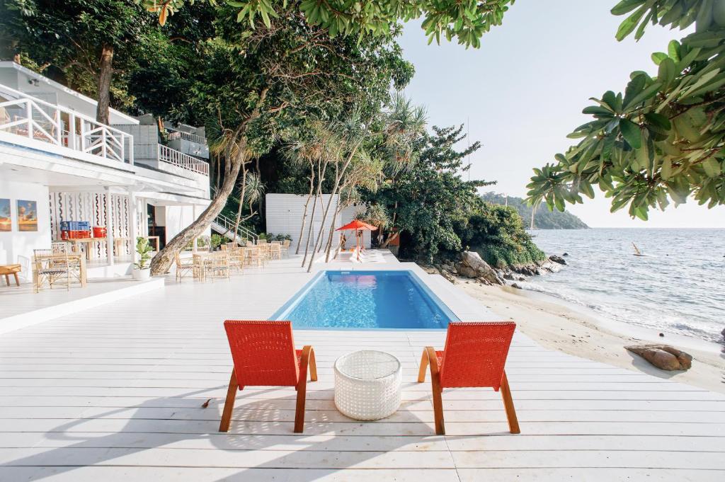 ดาดฟ้าไม้พร้อมเก้าอี้และสระน้ำบนชายหาดที่โรงแรมแห่งหนึ่งในสตูล โรงแรมสตูล