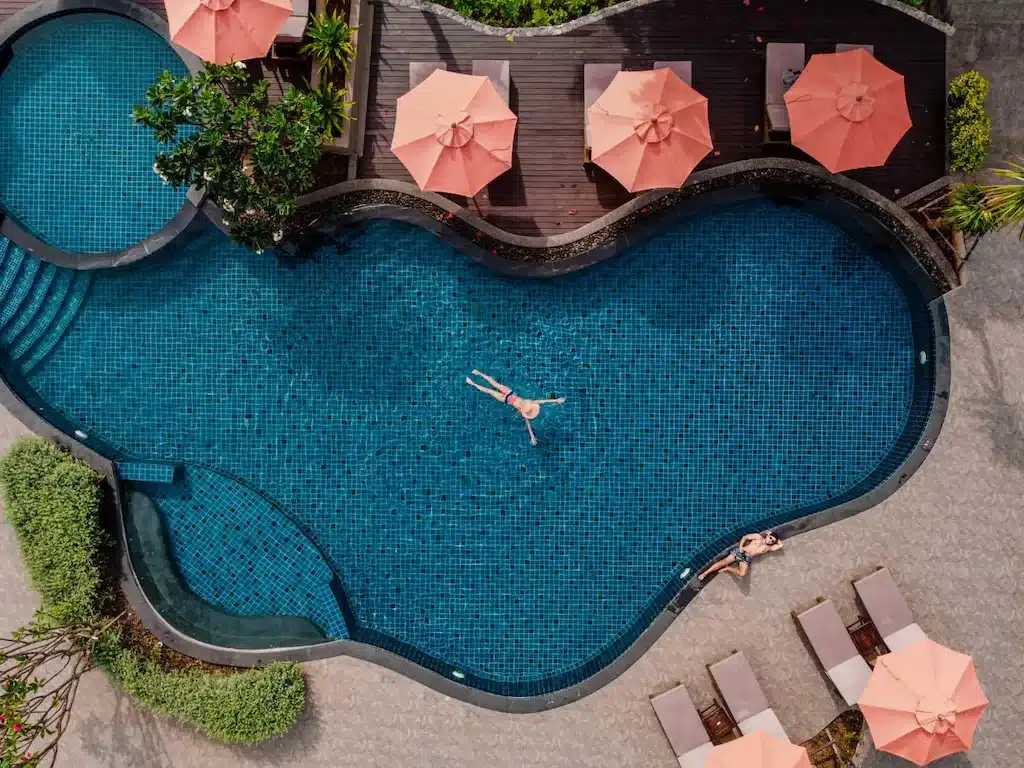 มุมมองทางอากาศของสระว่ายน้ำและเก้าอี้เลานจ์ที่โรงแรมแห่งหนึ่งในนครศรีธรรมราช ที่พักนครศรีธรรมราช