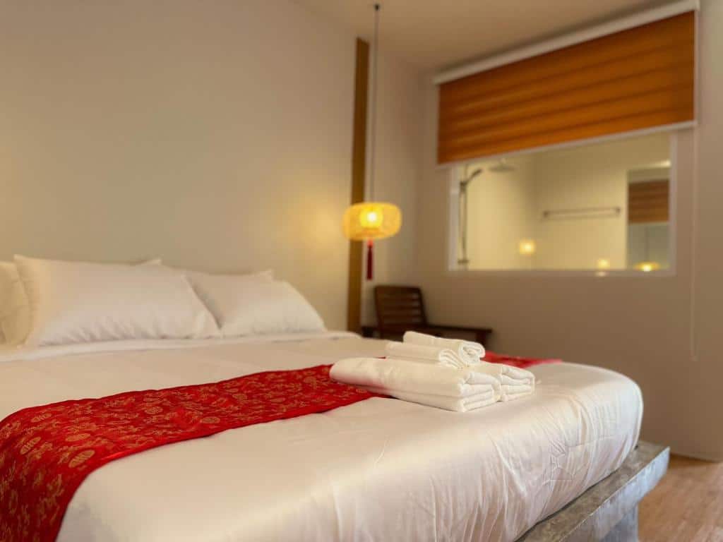 เตียงนอนพร้อมผ้า ที่พักบ้านรักไทย ห่มสีแดงขาวที่ บ้านรักไทยแม่ฮ่องสอนที่พัก