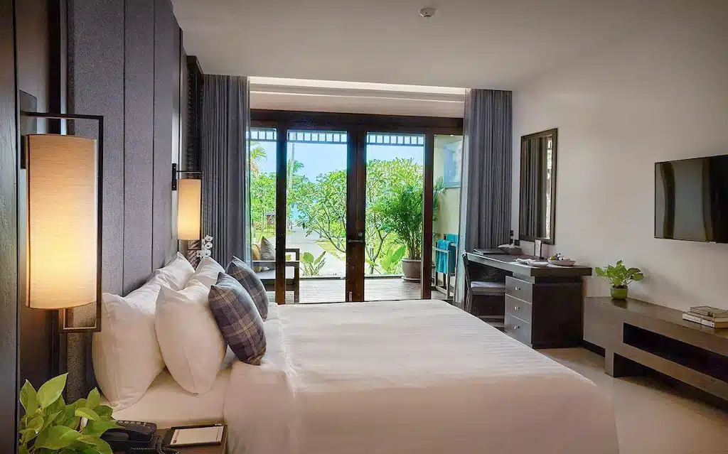 ห้องพักในโรงแรมที่มีเตียงและระเบียงมองเห็นวิวทะเลในจังหวัดนครศรีธรรมราช ที่พักนครศรีธรรมราช