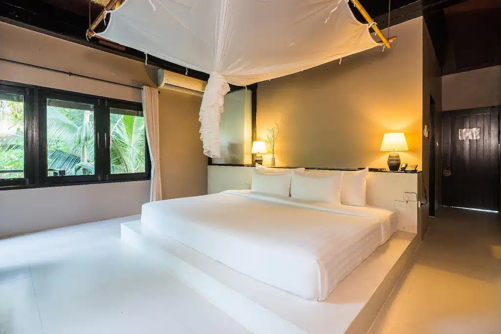 ที่พักเกาะกระดาน ห้องนอนสีขาวที่มีหลังคาคลุมเตียงพร้อมนำเสนอเกาะกระดาน