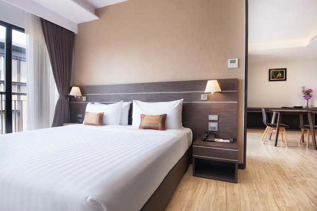 ห้องพักในโรงแรมที่มีพื้นไม้และเตียงในหนองคาย ที่พักหนองคาย