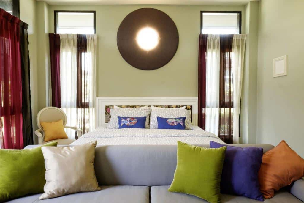 ห้องพักในโรงแรมพร้อมเตียงและหมอนหลากสีสันใน โรงแรมสมุทรสงคราม