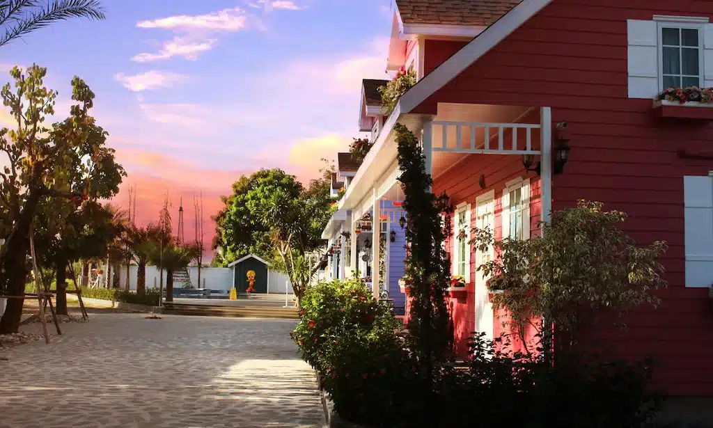 บ้านสีแดงแถวๆ ริมถนนยามพระอาทิตย์ตกดิน พร้อมตัวเลือกที่พักพูลวิลล่านครนายก (พูลวิลล่า) พูลวิลล่านครนายก