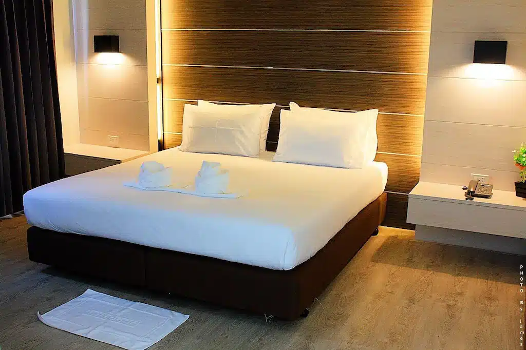 เตียงในห้องพักโรงแรมที่มีผ้าเช็ดตัวอยู่ในนั้นพัทลุง,โรงแรมพัทลุง. โรงแรมพัทลุง