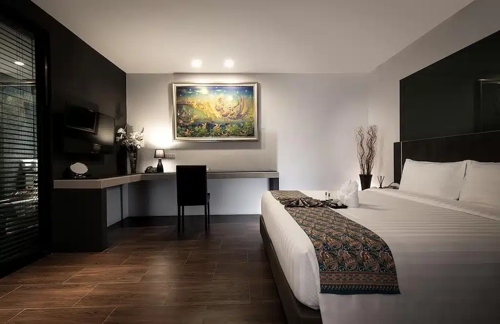 ห้องพักในโรงแรมที่นครศรีธรรมราชมีเตียงและภาพวาดบนผนัง โรงแรมในเมืองนครศรีธรรมราช
