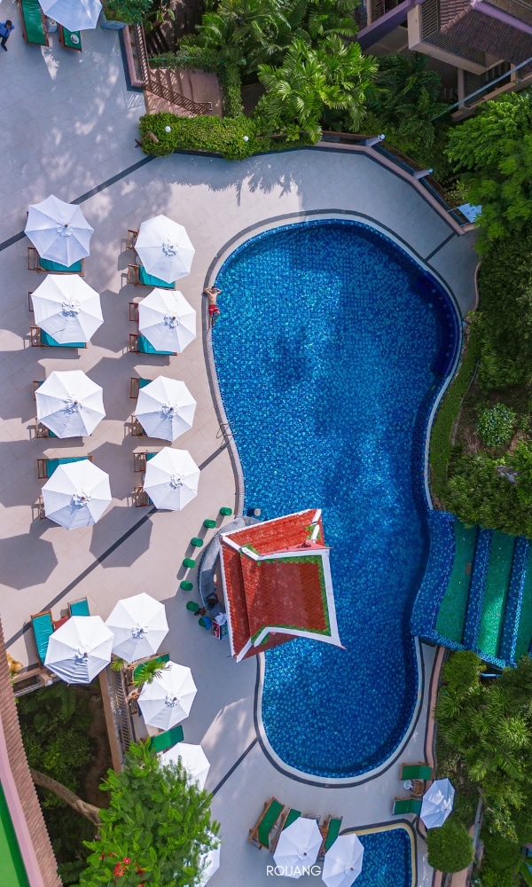 มุมมองทางอากาศของบริเวณสระว่ายน้ำชนาลัย การ์เดน รีสอร์ท ประดับด้วยร่มและเก้าอี้ Chanalai garden resort