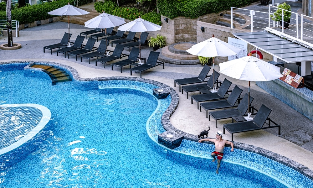 โรงแรมภูเก็ตพร้อมสระว่ายน้ำพร้อมเก้าอี้นั่งเล่นและร่ม โรงแรมภูเก็ต