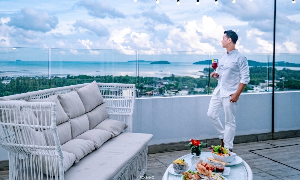 ผู้ชายยืนอยู่บนระเบียงที่โรงแรมโนโวเทล ภูเก็ต ซิตี้ โภคีธรา มองเห็นทะเล Novotel phokeethra Phuket