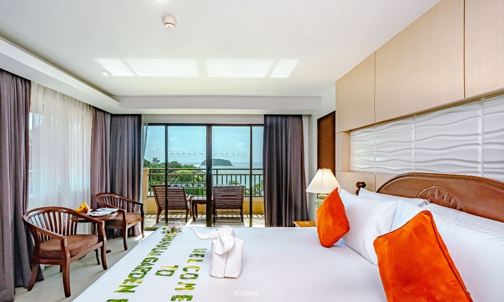 เตียงในห้องที่ชนาลัย การ์เดน รีสอร์ท พร้อมทิวทัศน์ของมหาสมุทร Chanalai garden resort