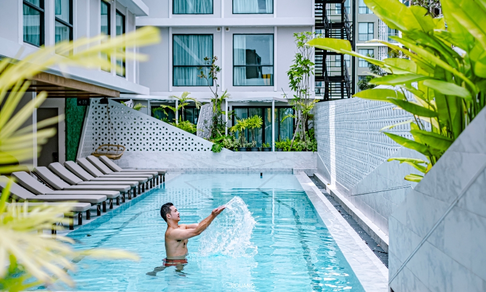 Travelodge Phuket Town ชายคนหนึ่งกำลังว่ายน้ำในสระว่ายน้ำหน้าอาคารทราเวลลอดจ์ ภูเก็ตทาวน์