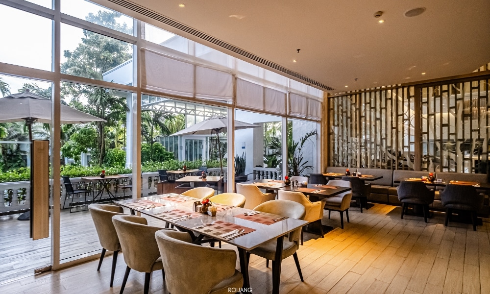 ห้องอาหารโนโวเทล ภูเก็ต ซิตี้ โภคีธรามีหน้าต่างบานใหญ่และโต๊ะไม้ Novotel phokeethra Phuket
