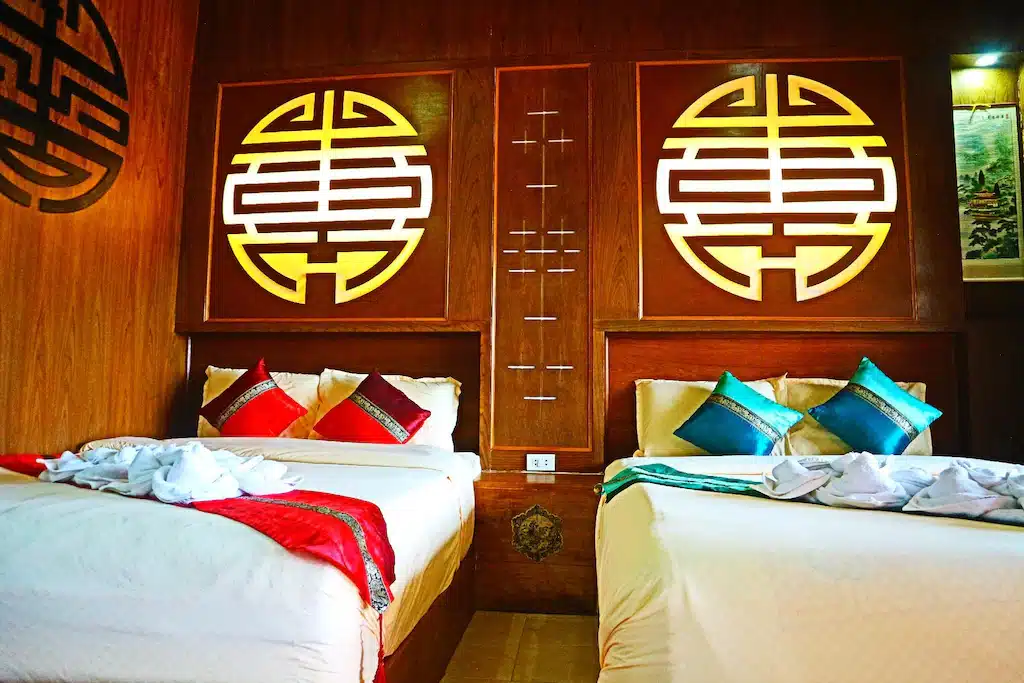 เตียงสองเตียงในห้องตกแต่งด้วยแบบจีนที่บ้านรักไทยแม่ฮ่องสอน  ที่พักบ้านรักไทย 