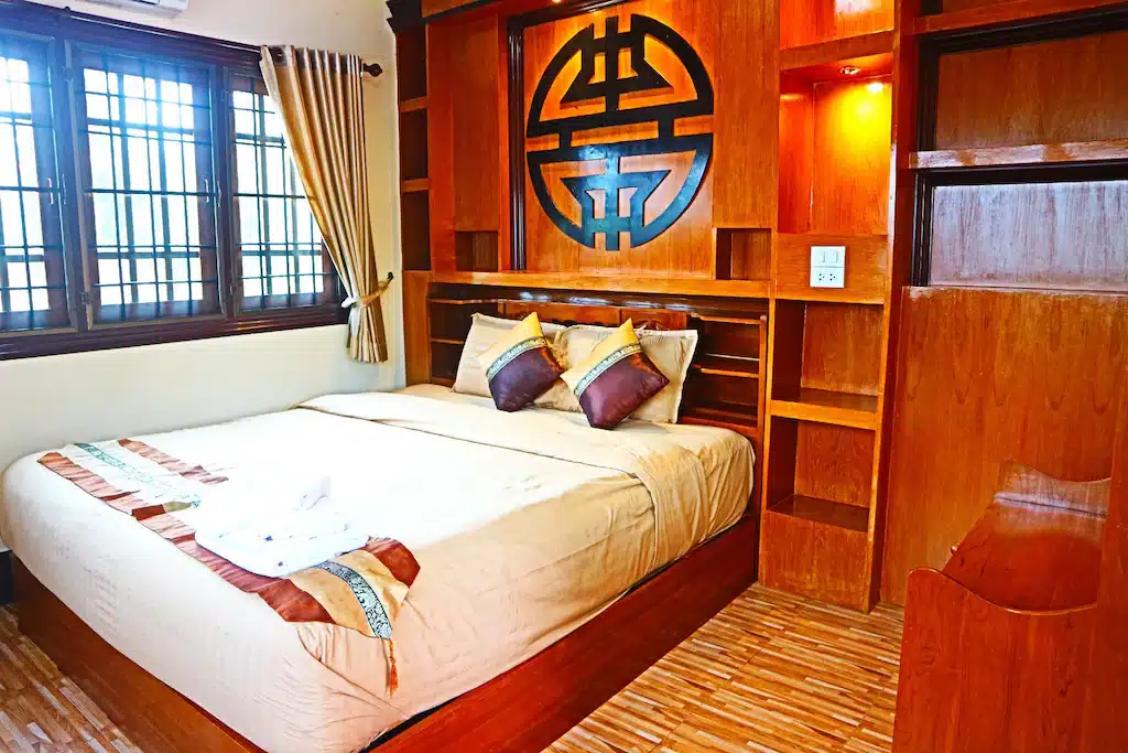 บ้านรักไทย ห้องนอนแสนสบายพร้อมเตียงนุ่มสบายและโต๊ะข้างเตียงมีสไตล์