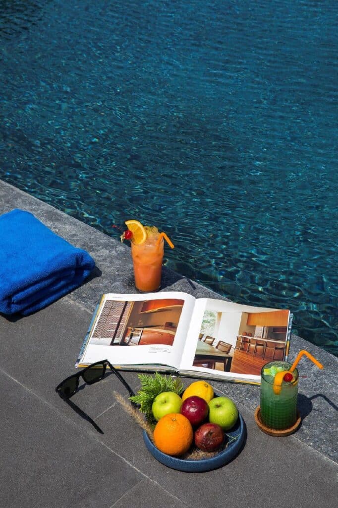จานผลไม้และหนังสือข้างสระว่ายน้ำในจังหวัดราชบุรีที่สวยงาม ที่เที่ยวบางแสน