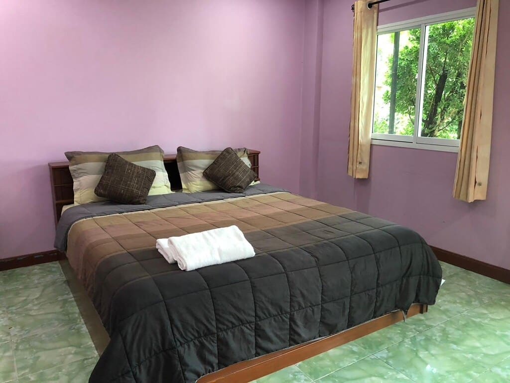 ห้องพักในโรงแรมผนังสีม่วงและเตียงนอนในพัทลุง โรงแรมพัทลุง