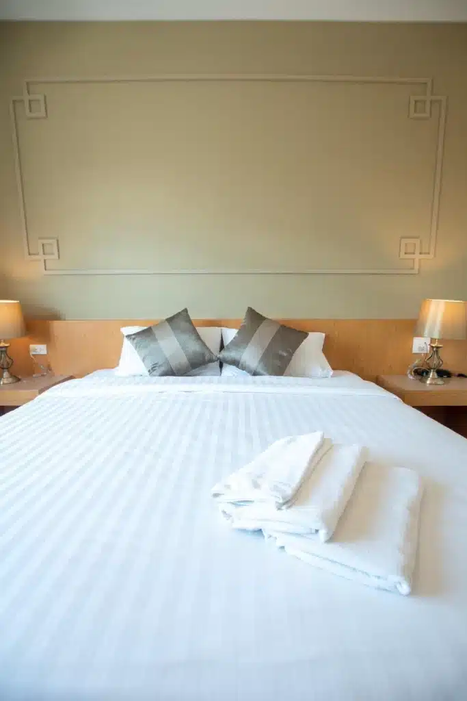 เตียงสีขาวในห้องพักของ โรงแรมในระนอง