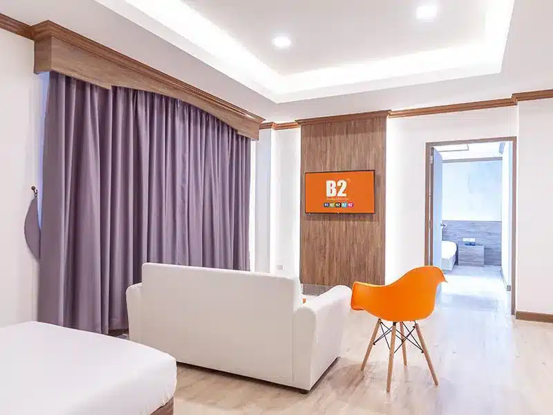ห้องพักในโรงแรมพร้อมเตียงและเก้าอี้สีส้ม ในโรงแรมนครศรีธรรมราช (นครศรีธรรมราช) ที่พักนครศรีธรรมราช