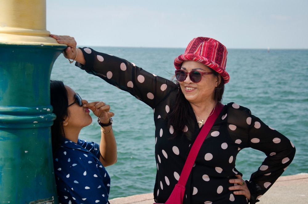 ผู้ ที่เที่ยวบางแสน หญิงสองคนเพลิดเพลินกับทิวทัศน์ริมน้ำที่ราชบุรี บางแสน