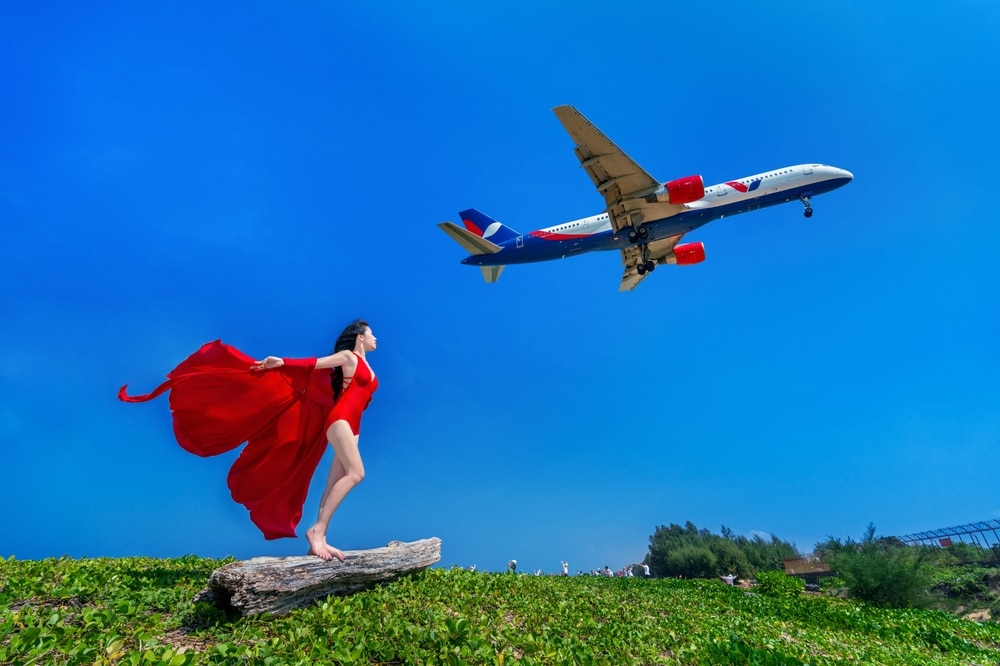 ผู้หญิงชุดแดง บินอยู่เหนือเครื่องบิน ระหว่างเที่ยวสงกรานต์ ที่เที่ยวหน้าร้อน