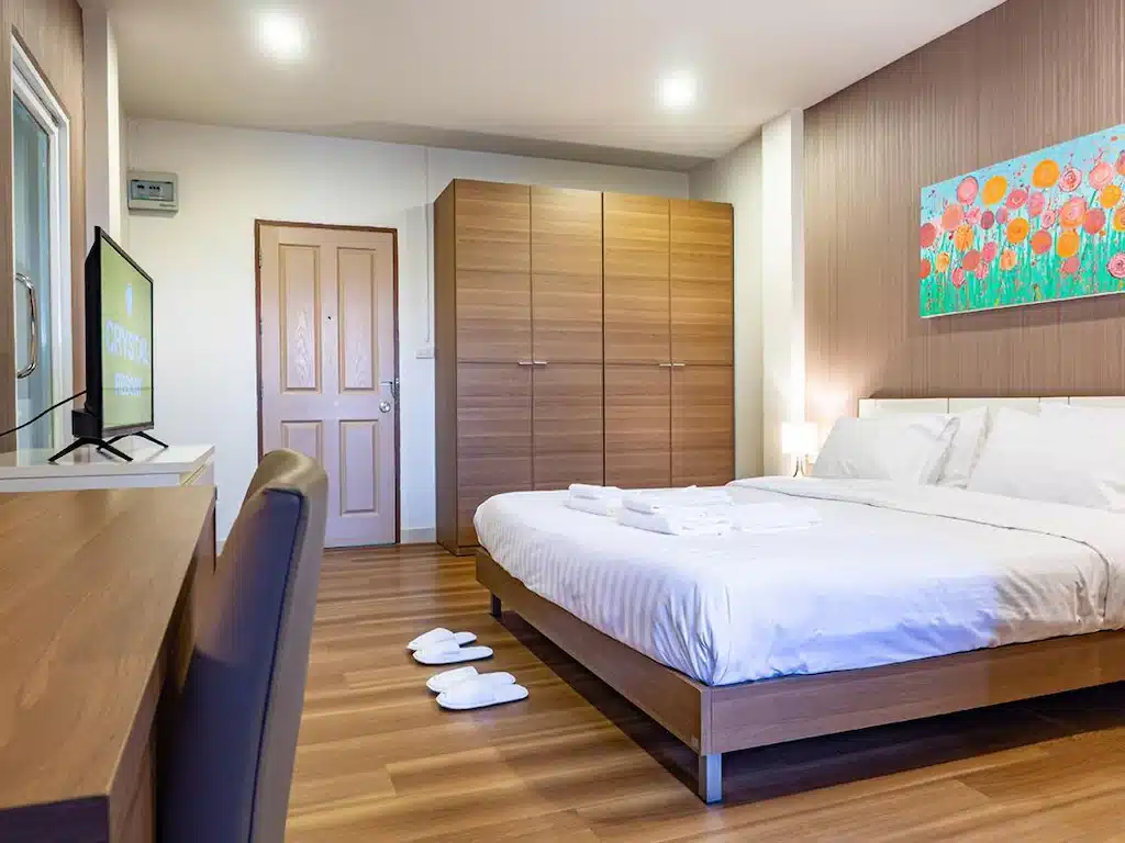ห้องนอนพร้อมเตียงขนาดใหญ่และภาพวาดบนผนังในโรงแรมนครราชสีมา ที่พักนครราชสีมา