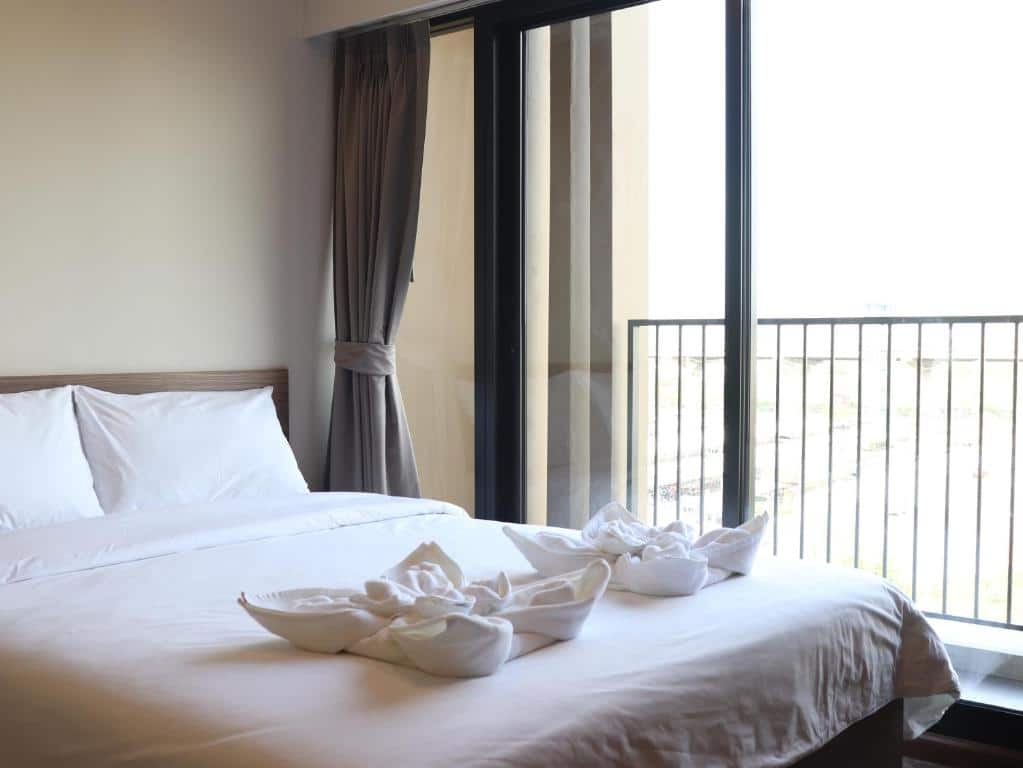 เตียงในห้องพร้อมวิวระเบียงที่โรงแรมแห่งหนึ่งในจังหวัดปทุมธานี ที่พักปทุมธานี