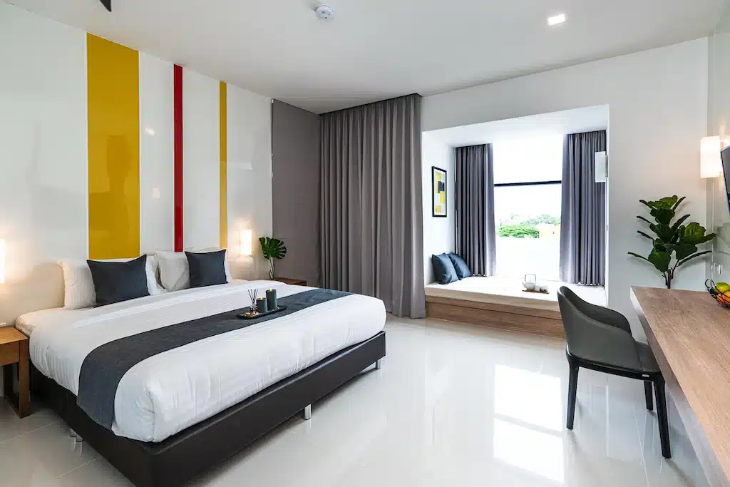 ห้องพักโรงแรมทันสมัยพร้อมแถบสีเหลืองและสีขาว ตั้งอยู่ในจังหวัดร้อยเอ็ด ประเทศไทย โรงแรมร้อยเอ็ด