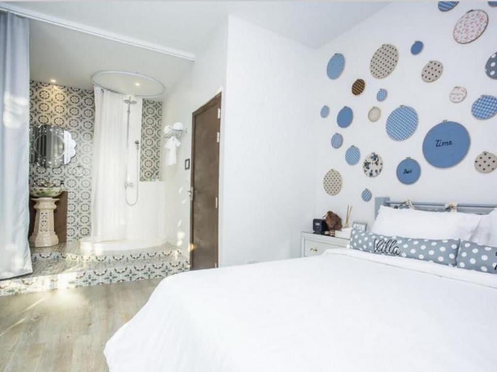 เตียงในห้องที่มีวงกลมสีฟ้าอยู่บนผนัง ที่เที่ยวราชบุรีสวนผึ้ง
