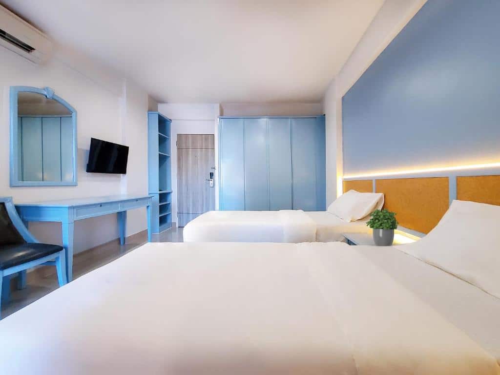 เตียงสองเตียงในห้องที่มีผนังสีฟ้าและเฟอร์นิเจอร์สีขาวที่ โรงแรมโนโวเทลรังสิต 