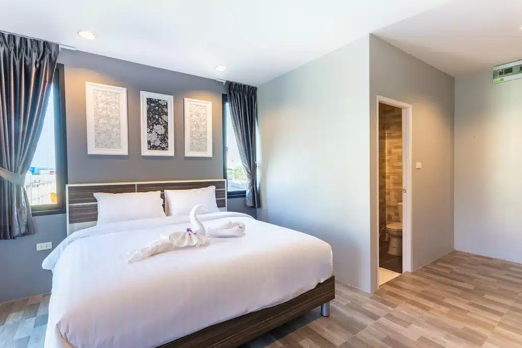 ห้องนอนพร้อมเตียงสีขาวและพื้นไม้ในราชบุรีที่เที่ยว ที่เที่ยวสมุทรสาคร