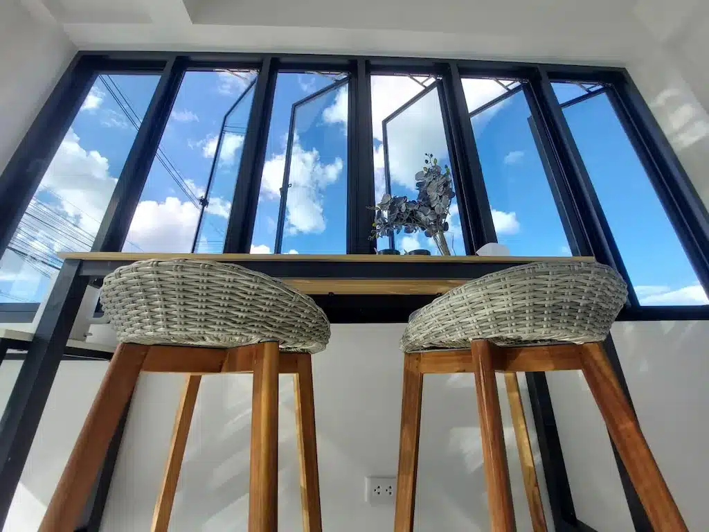เก้าอี้หวายสองตัวอยู่หน้าหน้าต่างมีค่าบริการร้อยเอ็ด โรงแรมร้อยเอ็ด